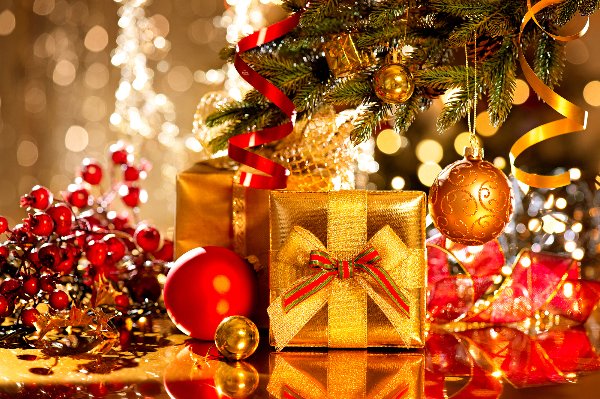 Geschenke liegen unter dem erleuchteten Weihnachtsbaum