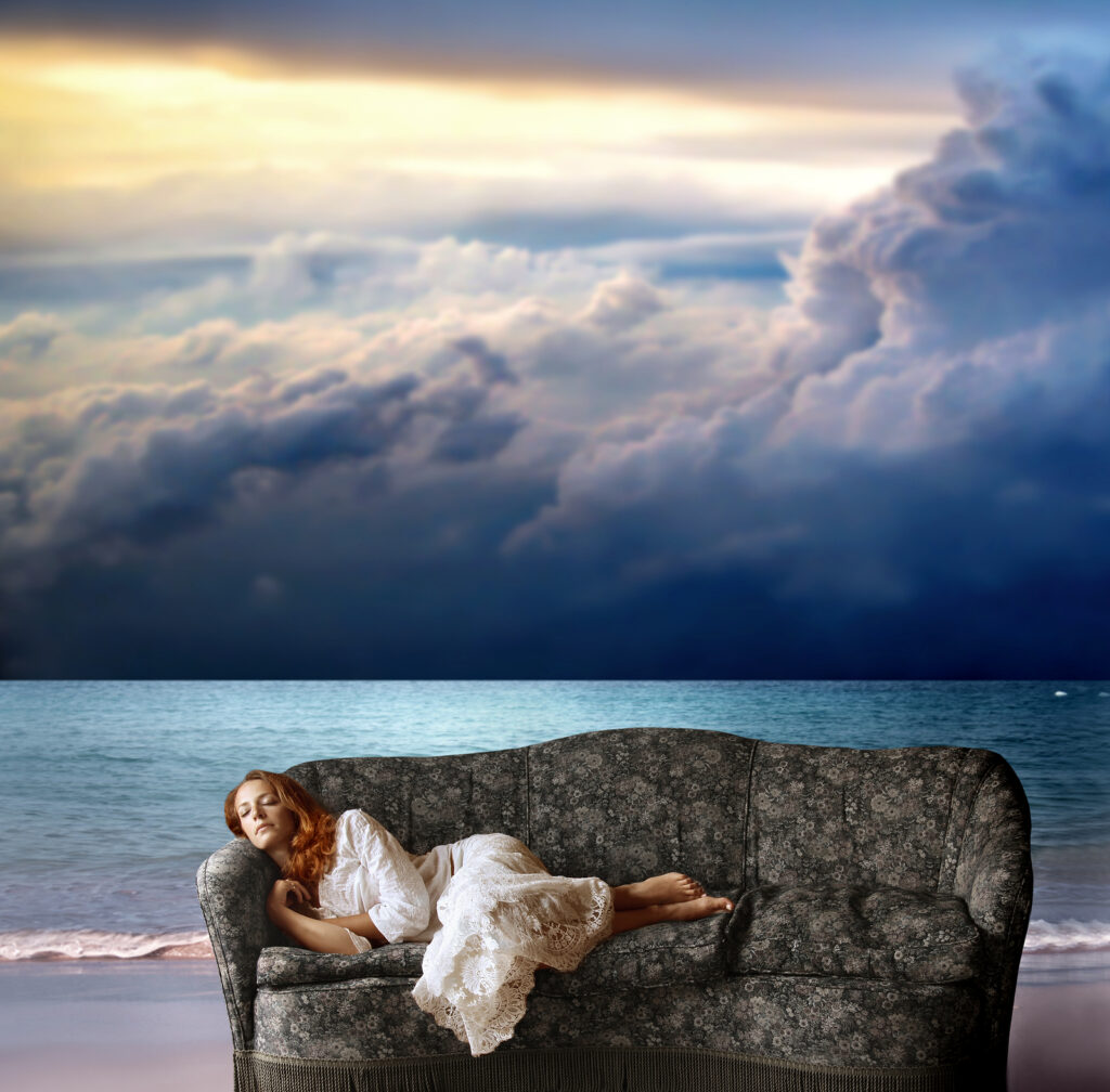 Eine Frau, die auf einem Sofa an einem Strand liegt